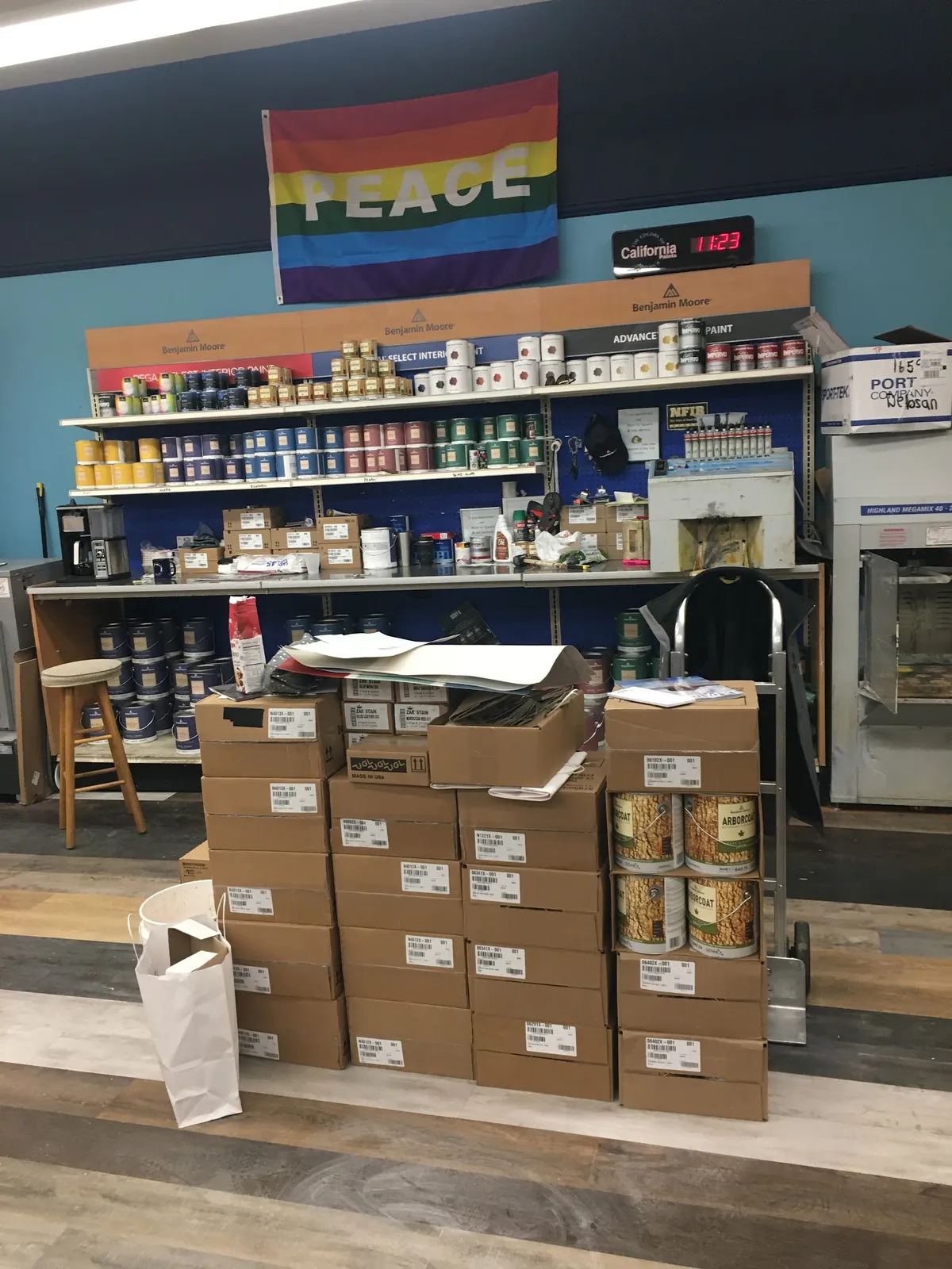 Benjamin Moore paint being chosen at the Debsan counter in Natick, with colour cards fanned out beside a can